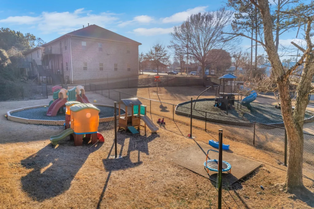 Playground at Chroma Early Learning Academy Marietta Campus featuring colorful slides, climbing structures, and a nature playground, designed for children's outdoor learning and play.