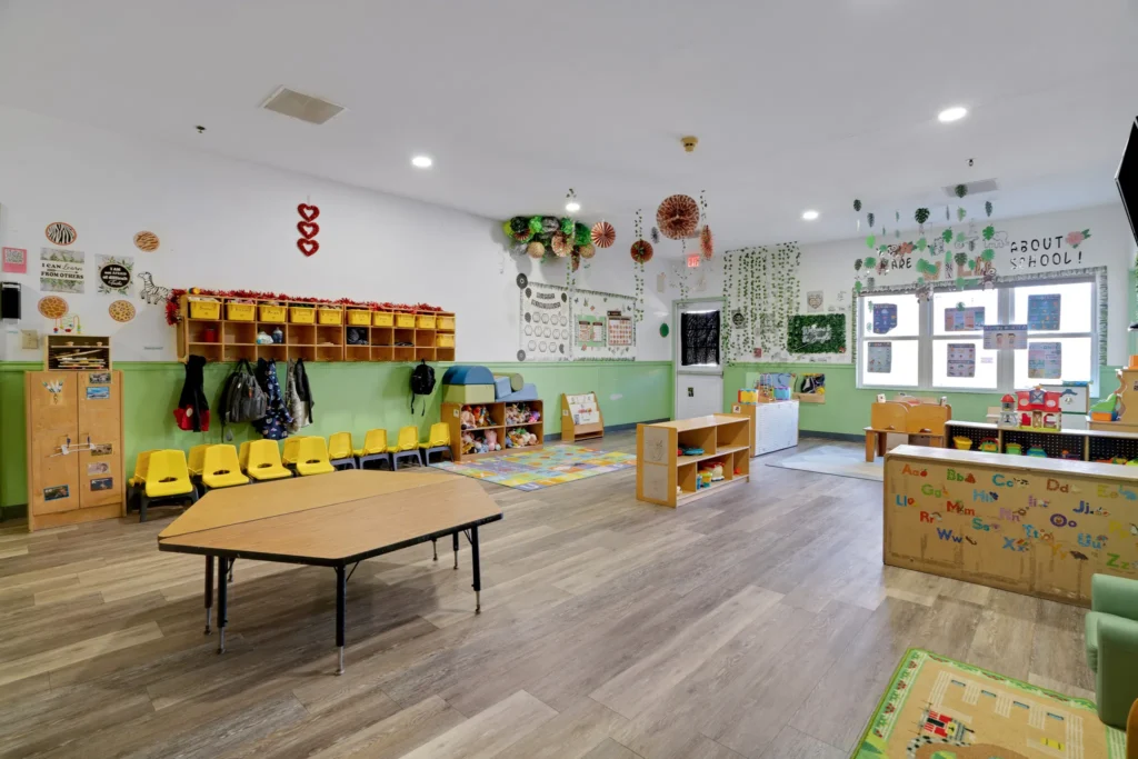 Brightly decorated early childhood classroom at Cherokee Academy, featuring colorful learning materials, yellow chairs, and a nurturing environment for children aged 6 weeks to 12 years.