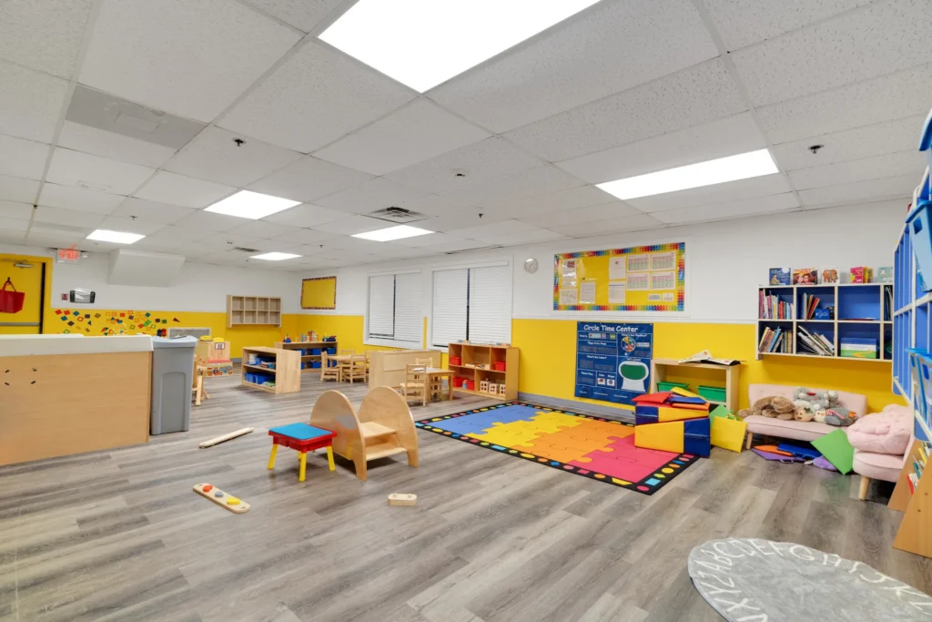 Brightly colored classroom at Chroma Early Learning Academy featuring playful furniture, a soft play area with foam mats, and educational resources, emphasizing a nurturing and engaging environment for early childhood learning.